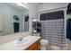 Well-lit bathroom featuring a sink, toilet, and shower with patterned curtain, and coordinated towels at 727 Skinner Rd, Shelby, NC 28152