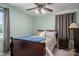 This bedroom is painted a calming light green, and includes a bed and a ceiling fan with light fixture at 727 Skinner Rd, Shelby, NC 28152