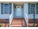Front porch stairs with red brick, white railings, and decorative front door at 727 Skinner Rd, Shelby, NC 28152