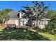 View of the back exterior with a spacious wooden deck, perfect for entertaining, surrounded by lush greenery at 944 Evian Ln, Matthews, NC 28015