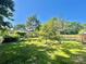 A beautifully landscaped backyard featuring mature trees, manicured lawn, and privacy fence at 944 Evian Ln, Matthews, NC 28015