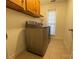 Functional laundry room featuring neutral colored washer and dryer and cabinet storage at 944 Evian Ln, Matthews, NC 28015