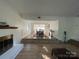 Spacious living room with a white brick fireplace, seamlessly connecting to a dining area on a raised platform at 944 Evian Ln, Matthews, NC 28015