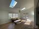 Bright living room featuring skylights, wood floors and a ceiling fan at 944 Evian Ln, Matthews, NC 28015