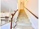 Bright stairway featuring carpeted steps, wooden handrail, and white risers leading to the upper level at 944 Evian Ln, Matthews, NC 28015