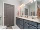 Bathroom featuring double sinks with bright lighting and stylish gray vanities at 1000 E Woodlawn Rd # 315, Charlotte, NC 28209