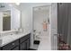 Well-lit bathroom with a vanity, mirror, black and white tile flooring, and modern fixtures at 1000 E Woodlawn Rd # 315, Charlotte, NC 28209