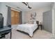 Bedroom with ceiling fan, a whitewashed wood accent wall, and a convenient desk area at 1000 E Woodlawn Rd # 315, Charlotte, NC 28209