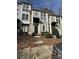 Inviting townhouse featuring neutral siding, black awnings, and well-maintained landscaping leading to the front door at 1049 Park West Dr, Charlotte, NC 28209