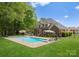 Resort-style backyard featuring a sparkling pool, lounge chairs, and lush landscaping at 105 Walnut Hill Ct, Mooresville, NC 28115