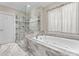 A stunning bathroom features a glass-enclosed shower and a luxurious soaking tub at 105 Walnut Hill Ct, Mooresville, NC 28115