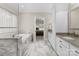 A marble tiled bathroom offers a soaking tub with a view into the main bedroom at 105 Walnut Hill Ct, Mooresville, NC 28115