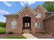 Charming brick home with inviting entryway, featuring decorative door and manicured landscaping at 105 Walnut Hill Ct, Mooresville, NC 28115
