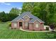 Stunning brick home with lush green lawn and mature trees offering a welcoming curb appeal at 105 Walnut Hill Ct, Mooresville, NC 28115