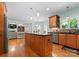 Open eat-in kitchen with wood cabinets and floors, stainless appliances, and large island at 105 Walnut Hill Ct, Mooresville, NC 28115