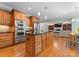 Spacious eat-in kitchen with stainless appliances, wood cabinets and floors open to living room at 105 Walnut Hill Ct, Mooresville, NC 28115