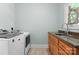 A functional laundry room offers a washer, dryer, sink and ample counter space at 105 Walnut Hill Ct, Mooresville, NC 28115