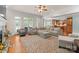 Open-concept living room featuring hardwood floors, a large sectional sofa, and backyard access at 105 Walnut Hill Ct, Mooresville, NC 28115