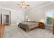 A well-lit main bedroom features a large bed, ceiling fan, carpeted floors and ample natural light at 105 Walnut Hill Ct, Mooresville, NC 28115