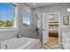 Bright bathroom boasts a large tub, glass-enclosed shower, and bedroom access at 10517 Sable Cap Rd, Mint Hill, NC 28227
