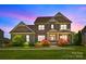Twilight image of a charming two-story brick home with manicured lawn at 10517 Sable Cap Rd, Mint Hill, NC 28227