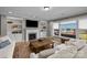 Spacious living room with built-in shelves, a fireplace, and a large window view of the lake at 10517 Sable Cap Rd, Mint Hill, NC 28227