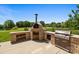 This outdoor kitchen features a pizza oven, grill and brick accents with wood storage at 10517 Sable Cap Rd, Mint Hill, NC 28227