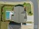 An aerial view of a home showcasing the swimming pool, driveway, and landscaping at 1107 Castle Rd, Indian Land, SC 29707