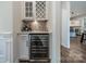 Stylish bar area features a built-in wine fridge, custom cabinets, attractive backsplash and quartz countertop at 1107 Castle Rd, Indian Land, SC 29707