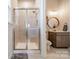 Bathroom showcasing tiled shower with sliding glass doors, vanity and decoratively framed mirror at 1107 Castle Rd, Indian Land, SC 29707
