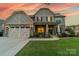 Charming two-story home with a stone facade, three-car garage, and manicured front lawn at 1107 Castle Rd, Indian Land, SC 29707