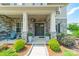 Inviting covered front porch with stone columns and decorative landscaping at 1107 Castle Rd, Indian Land, SC 29707