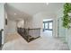 Upstairs hallway with carpet flooring, an open view to the main bedroom and wooden stair rail at 1107 Castle Rd, Indian Land, SC 29707