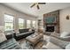 Cozy living room features a stone fireplace, comfortable seating, large windows, and ample natural light at 1107 Castle Rd, Indian Land, SC 29707