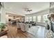Open-concept living room features hardwood floors, large windows, modern furnishings, fireplace and views of the kitchen at 1107 Castle Rd, Indian Land, SC 29707