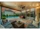 A covered patio offers comfortable seating, a ceiling fan, and outdoor string lights overlooking the pool at 1107 Castle Rd, Indian Land, SC 29707