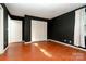 Bedroom featuring dark-colored walls, red-toned wood floors, and a closet door for ample storage at 1108 Old Dallas Hwy, Dallas, NC 28034