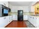 Functional kitchen with white cabinets, black appliances, and laminate wood flooring at 1108 Old Dallas Hwy, Dallas, NC 28034