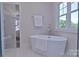 Bright bathroom featuring a standalone tub, tile floors, and large windows offering views of the outdoors at 116 S Broad St, Waxhaw, NC 28173