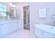Relaxing bathroom featuring a soaking tub, a glass shower, and a vanity with modern fixtures at 116 S Broad St, Waxhaw, NC 28173