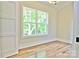Bright, empty bedroom with hardwood floors and natural light streaming through a large window at 116 S Broad St, Waxhaw, NC 28173