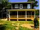 Charming two-story home with a covered porch, dark siding, and a well-manicured lawn at 116 S Broad St, Waxhaw, NC 28173
