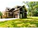 A dark colored two-story home features a two car garage, backyard and lawn at 116 S Broad St, Waxhaw, NC 28173