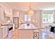 Well-lit kitchen with a center island, bar stool seating, modern appliances, and seamless transition into the dining area at 116 S Broad St, Waxhaw, NC 28173