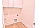 Functional laundry room with upper cabinets, wood floors, and utility hook-ups at 116 S Broad St, Waxhaw, NC 28173