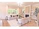 Bright living room with a fireplace, built-in shelving, hardwood floors, and stylish neutral furniture at 116 S Broad St, Waxhaw, NC 28173