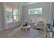 Bright, sunlit sitting room features hardwood floors, neutral furniture, and large windows at 116 S Broad St, Waxhaw, NC 28173