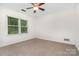 Bedroom featuring plush carpet, ceiling fan, and a bright window with scenic view at 1209 Alfred St, Charlotte, NC 28211