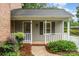 Charming front porch with gray siding, white railing, and landscaped garden at 1209 Alfred St, Charlotte, NC 28211