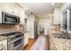 Well-lit kitchen features stainless steel appliances, tile backsplash, granite countertops, and hardwood floors at 1209 Alfred St, Charlotte, NC 28211